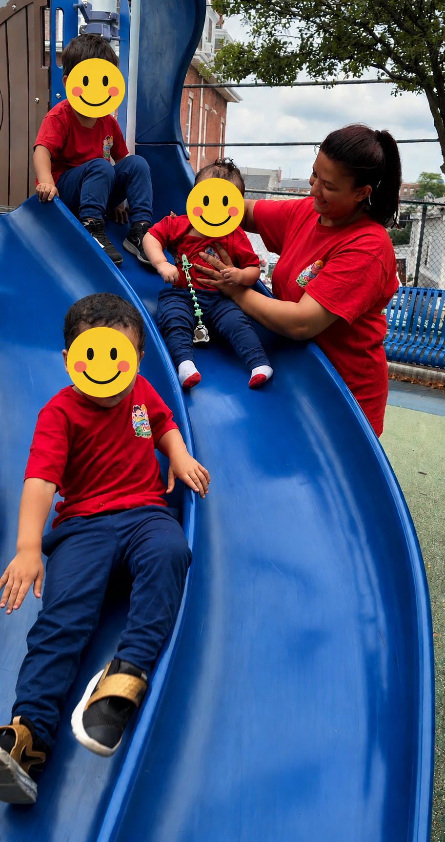 Adult and children sitting on a playground slide