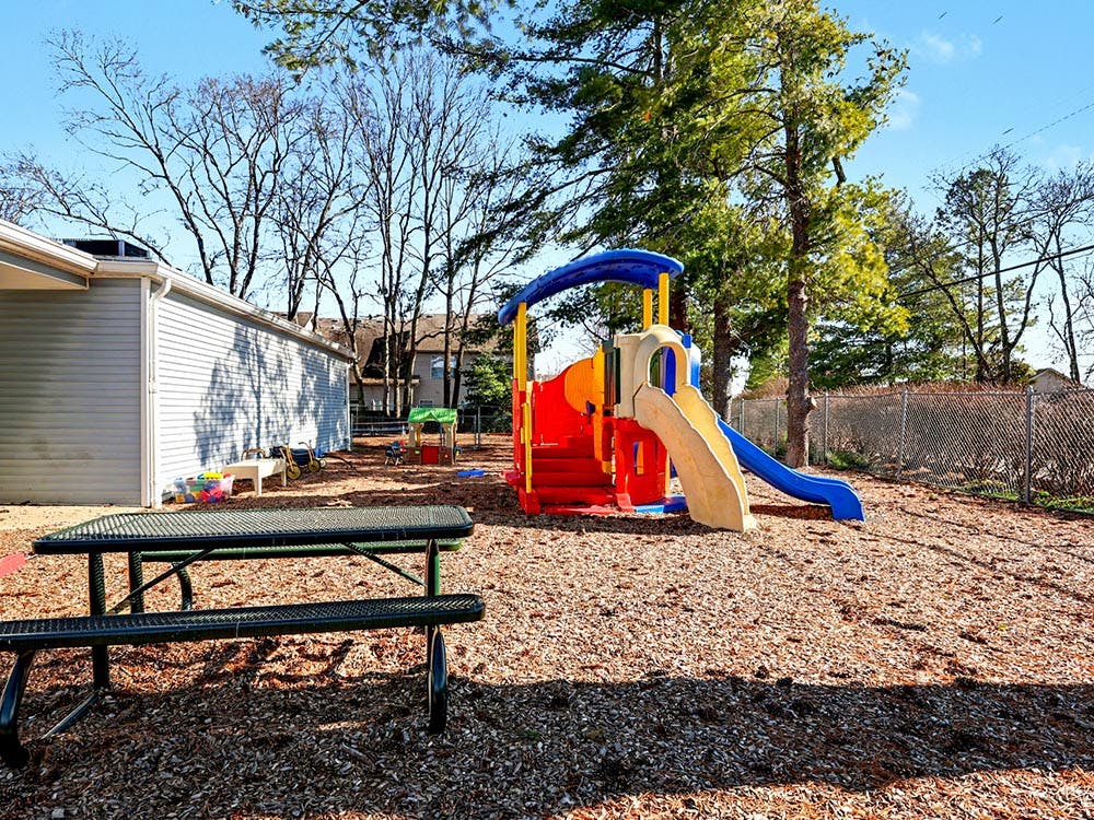 Playground with a bright colorful playset, slides, and picnic table
