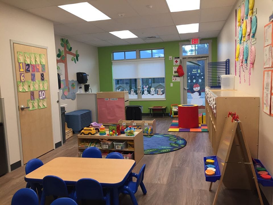 Preschool classroom with small tables, chairs, and toys