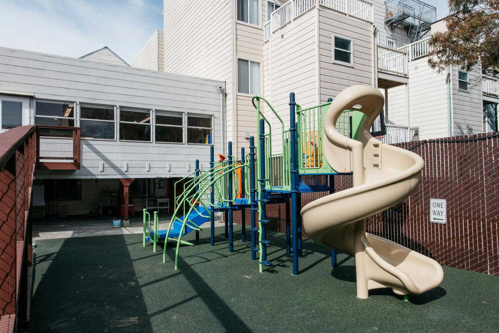 Playground with climbing structures, blue steps, and a beige spiral slide