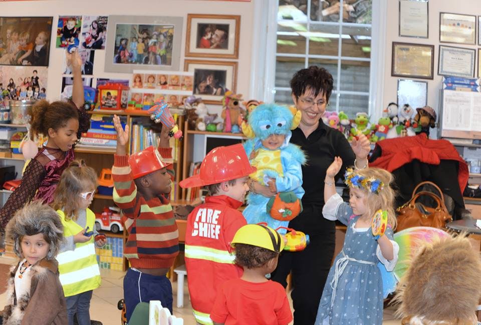 Adult and children in costumes in a classroom