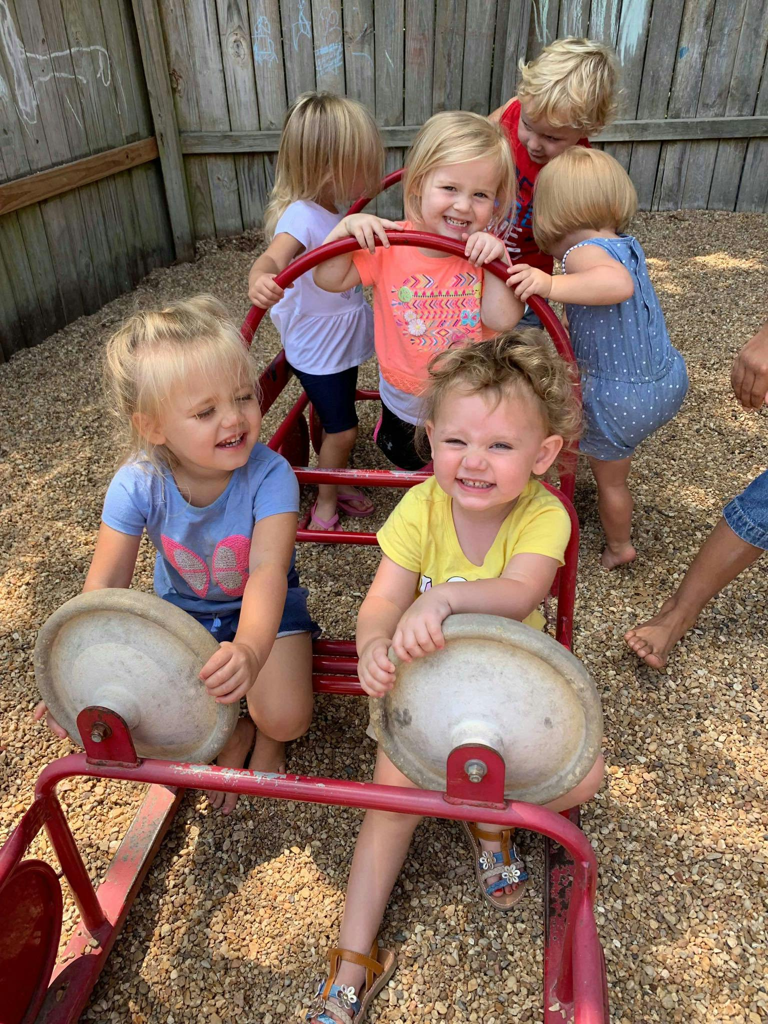 Multiple children playing on a red playground structure