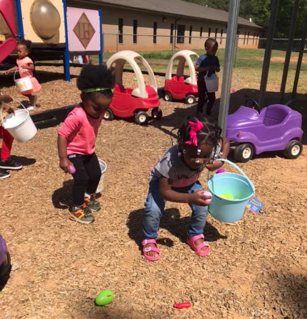 Children collecting items in buckets on a playground
