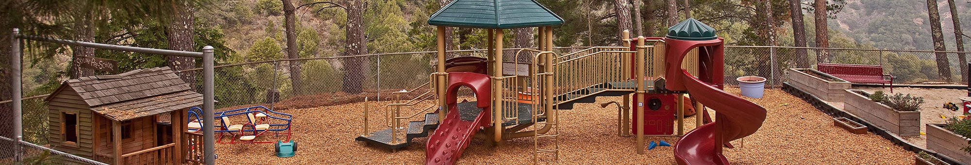 Playground with slides, swings, and a small playhouse
