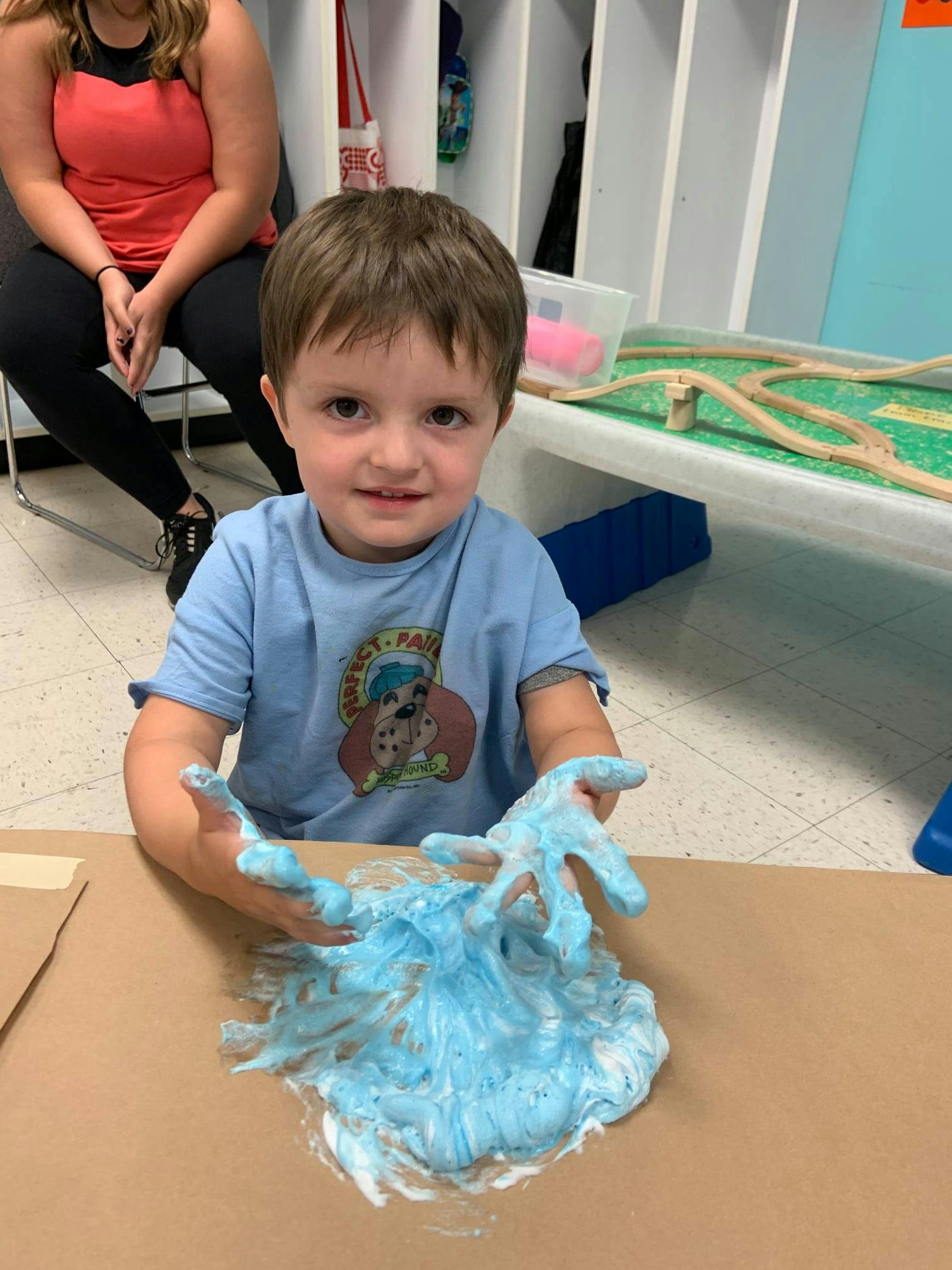Child playing with blue foam on a table