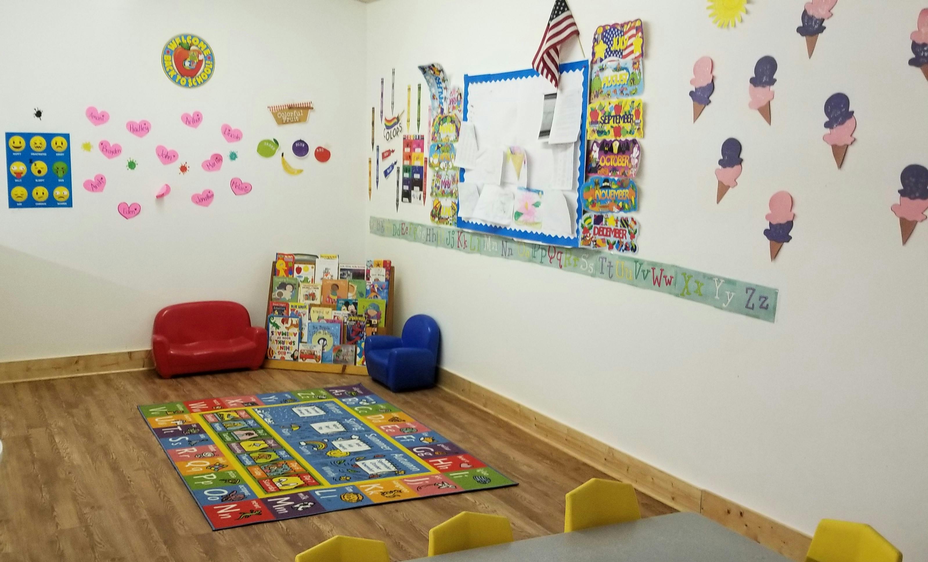 Classroom with colorful rug, small chairs, and wall decorations