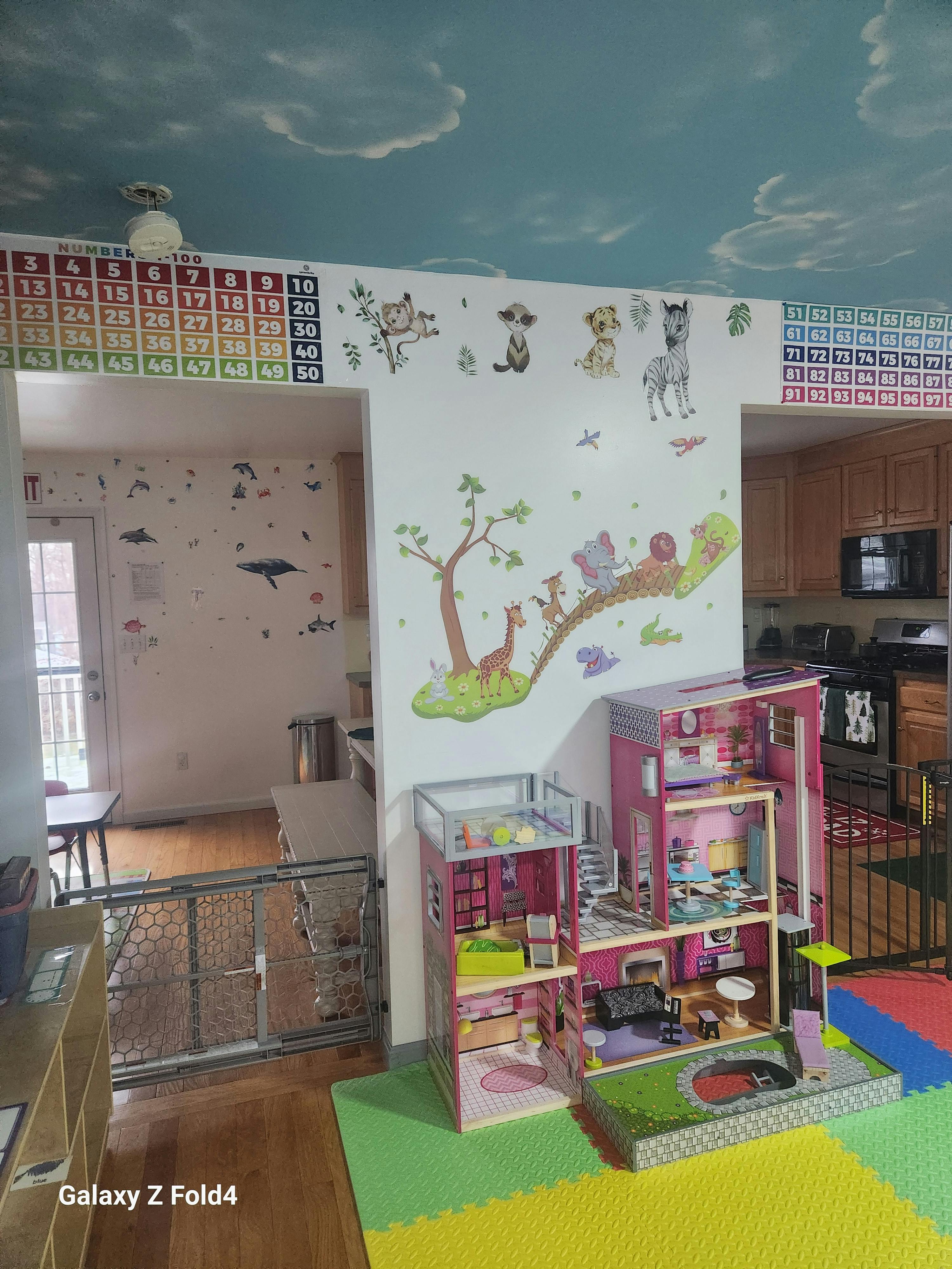 Playroom with dollhouse, wall decals, and number charts