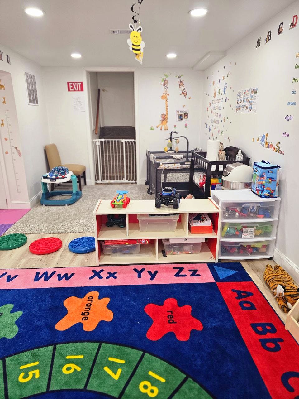 Playroom with colorful rug, crib, and storage shelves