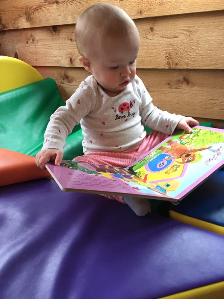 Child sitting and looking at a colorful book