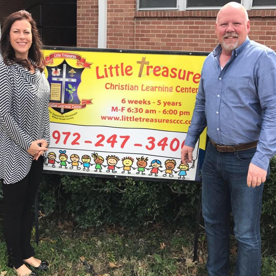 Two people standing next to a sign for Little Treasure Christian Learning Center