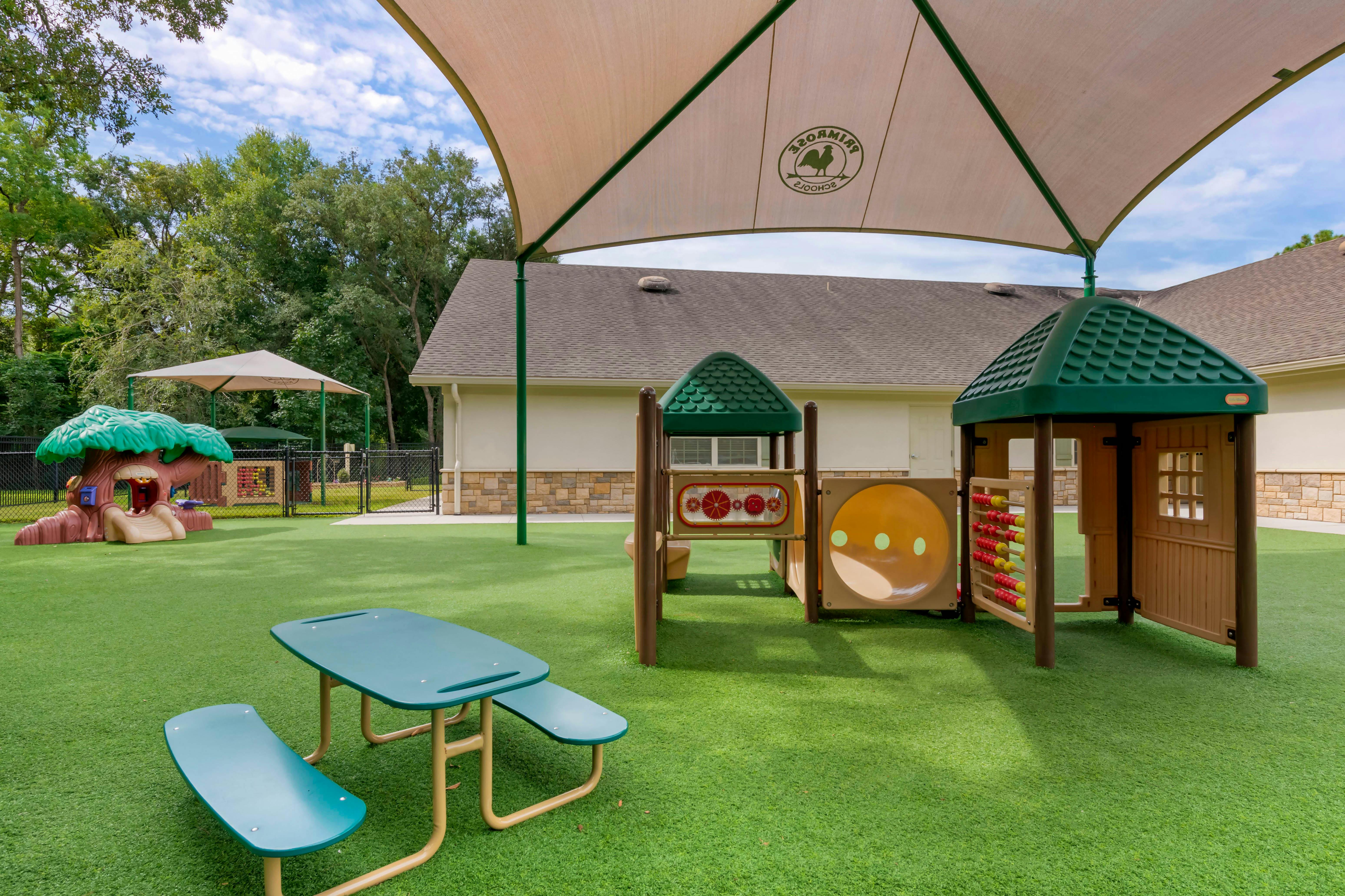 Playground with turf ground, picnic table, and play structures