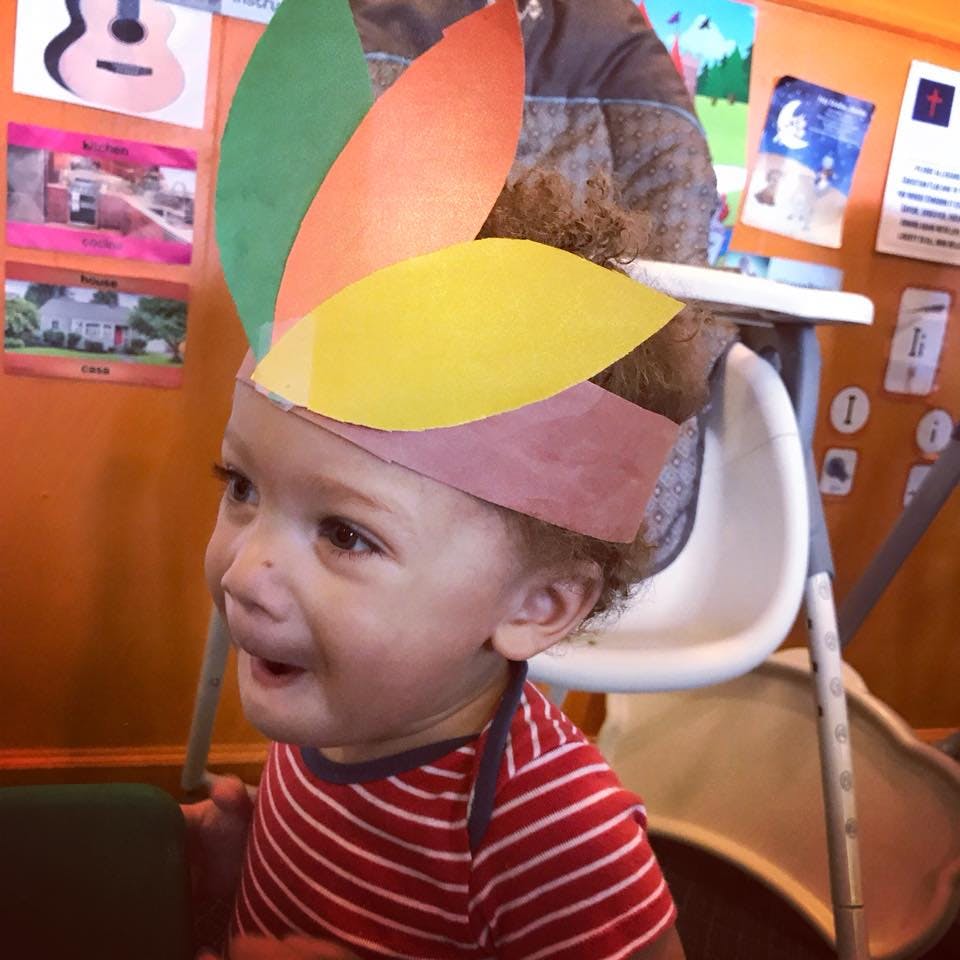 Child wearing a paper feather headdress