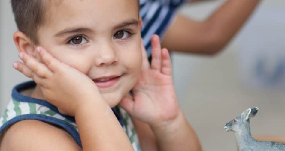 Child with hands on cheeks