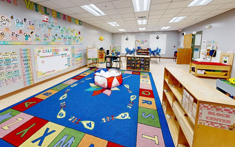 Classroom with an alphabet rug and calendar on the wall