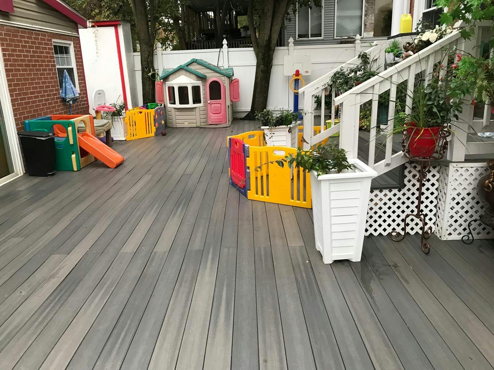 Deck with a playhouse, slide, and colorful play fences