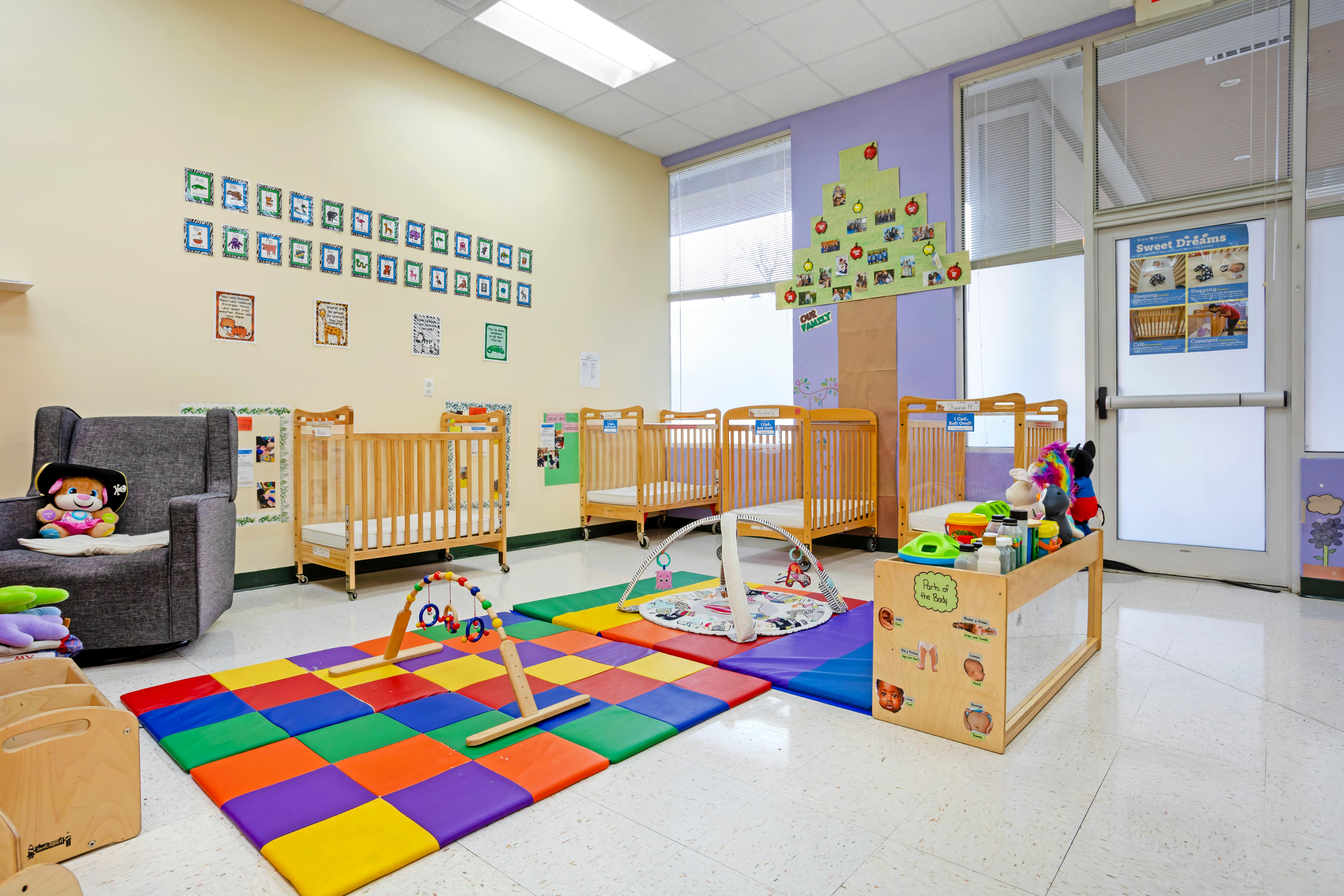Daycare room with cribs, play mats, and toys