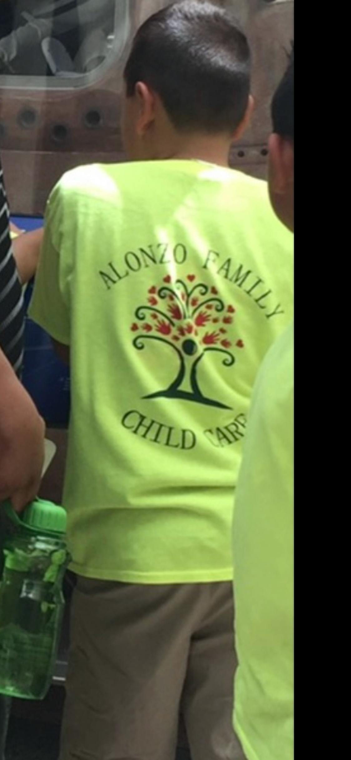 Child wearing a t-shirt with "Alonzo Family Child Care" logo