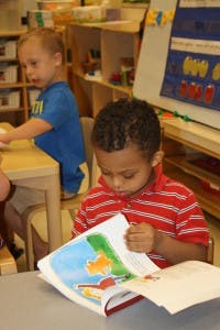 Child reading a book at a table