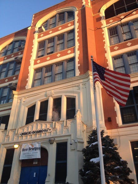 American flag flying in front of a brick building with many windows