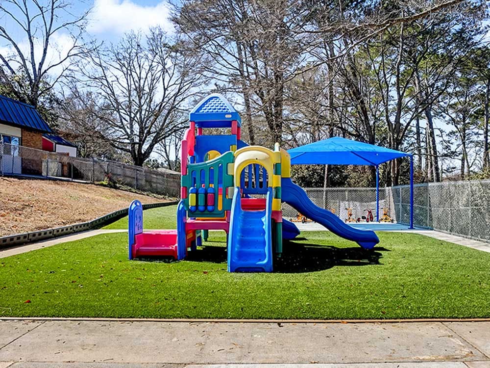 Colorful playground structure with slides on artificial turf