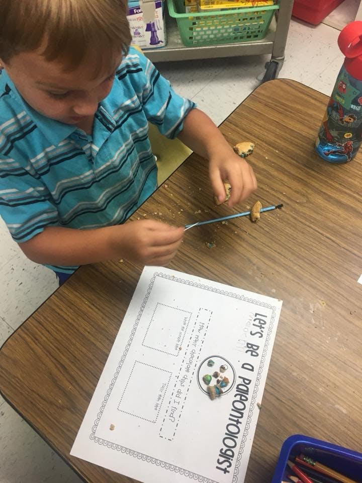 Child working on a craft project at a table