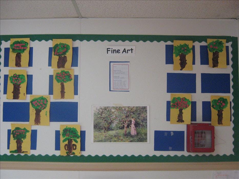 Children's tree paintings and a framed painting on a bulletin board labeled "Fine Art"