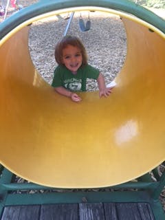 Child in a yellow tunnel slide