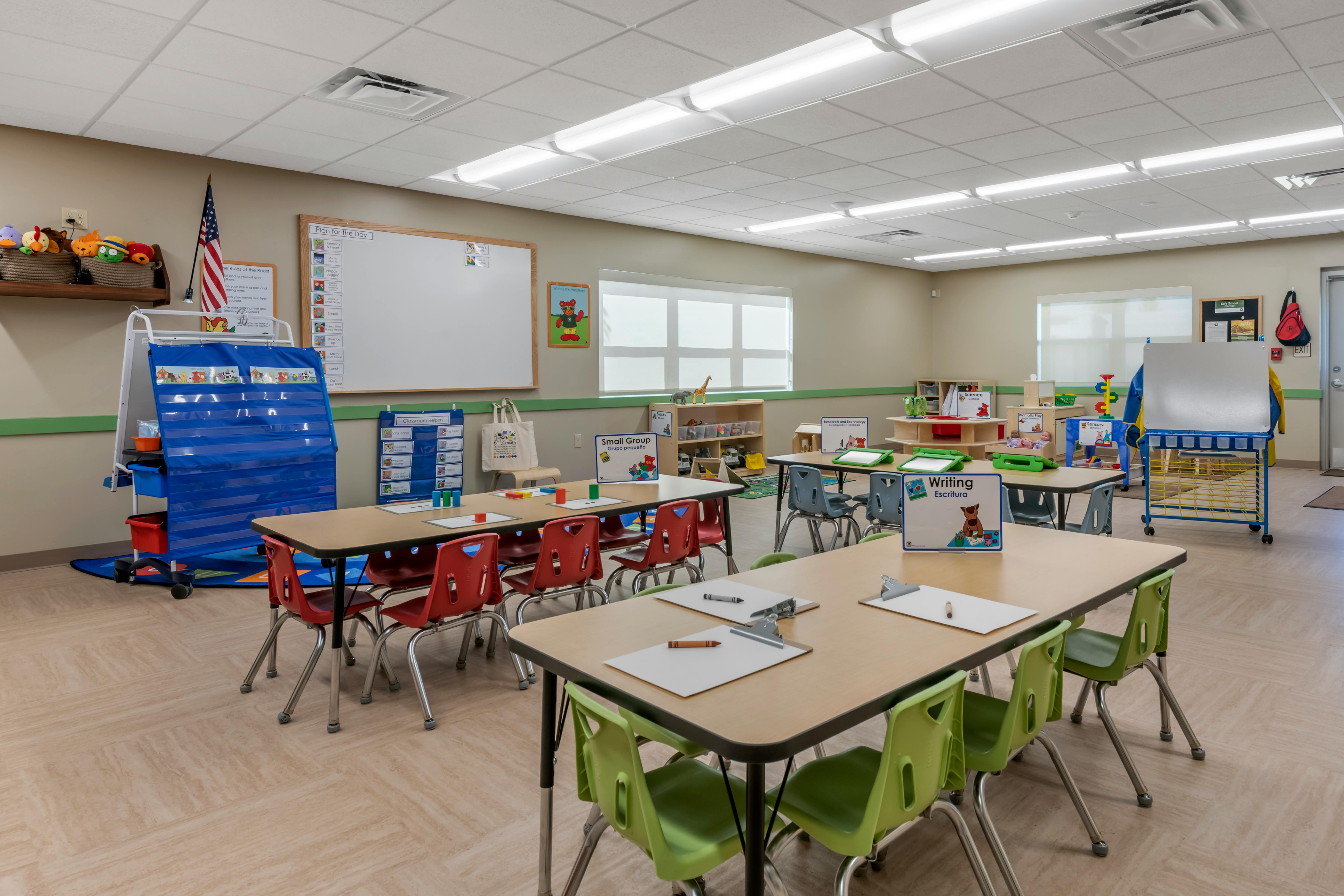 Classroom with small tables and chairs, whiteboards, and learning materials