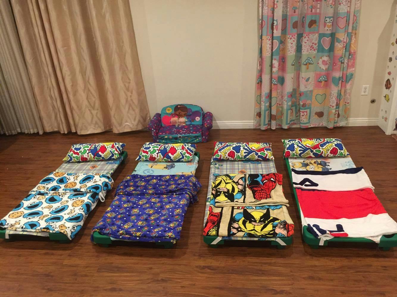 Four sleeping bags with pillows on a wooden floor