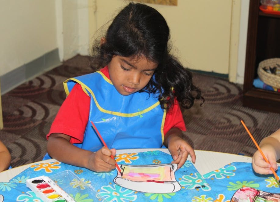 Child painting a picture at a table