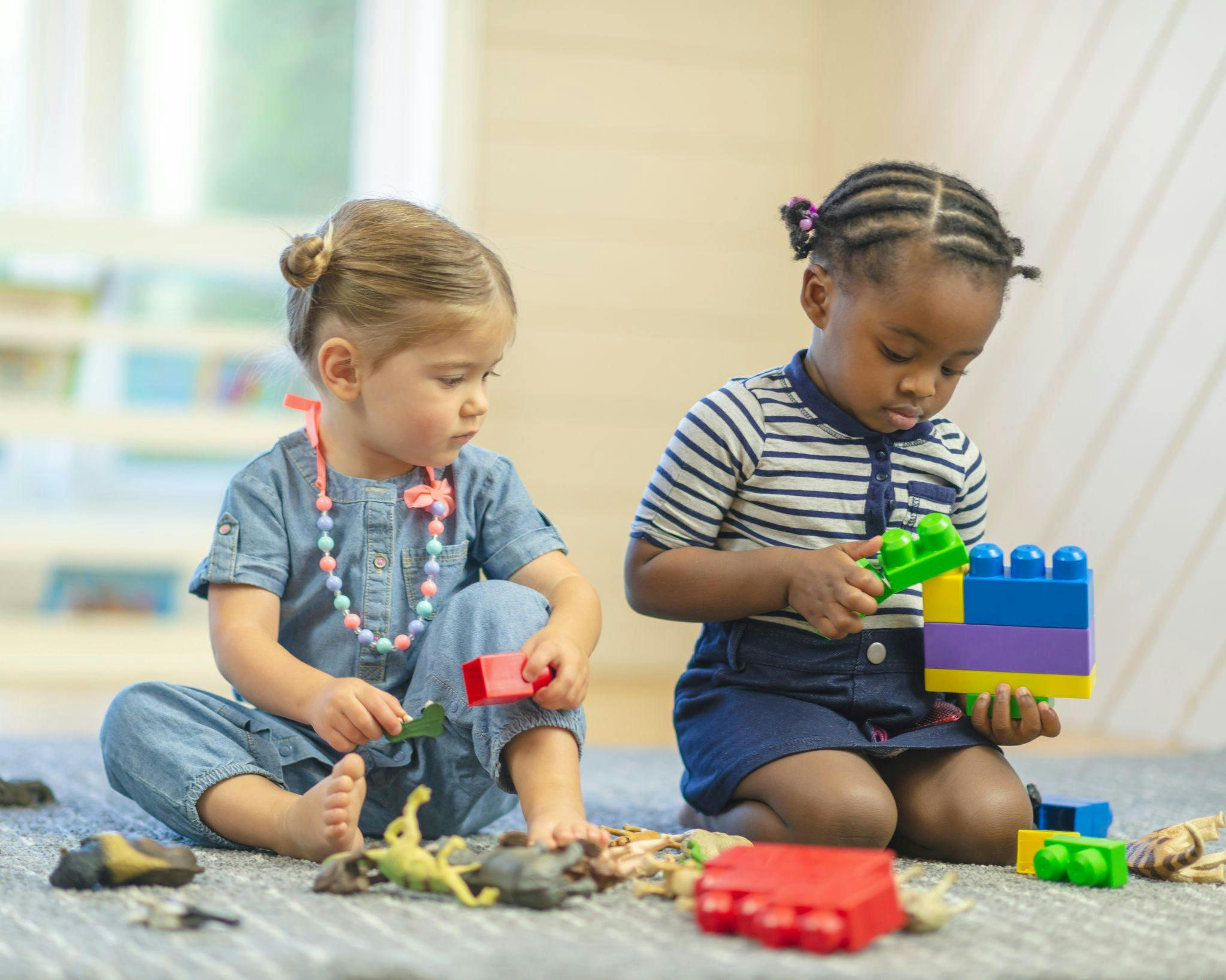 Two children playing with toys on the floor