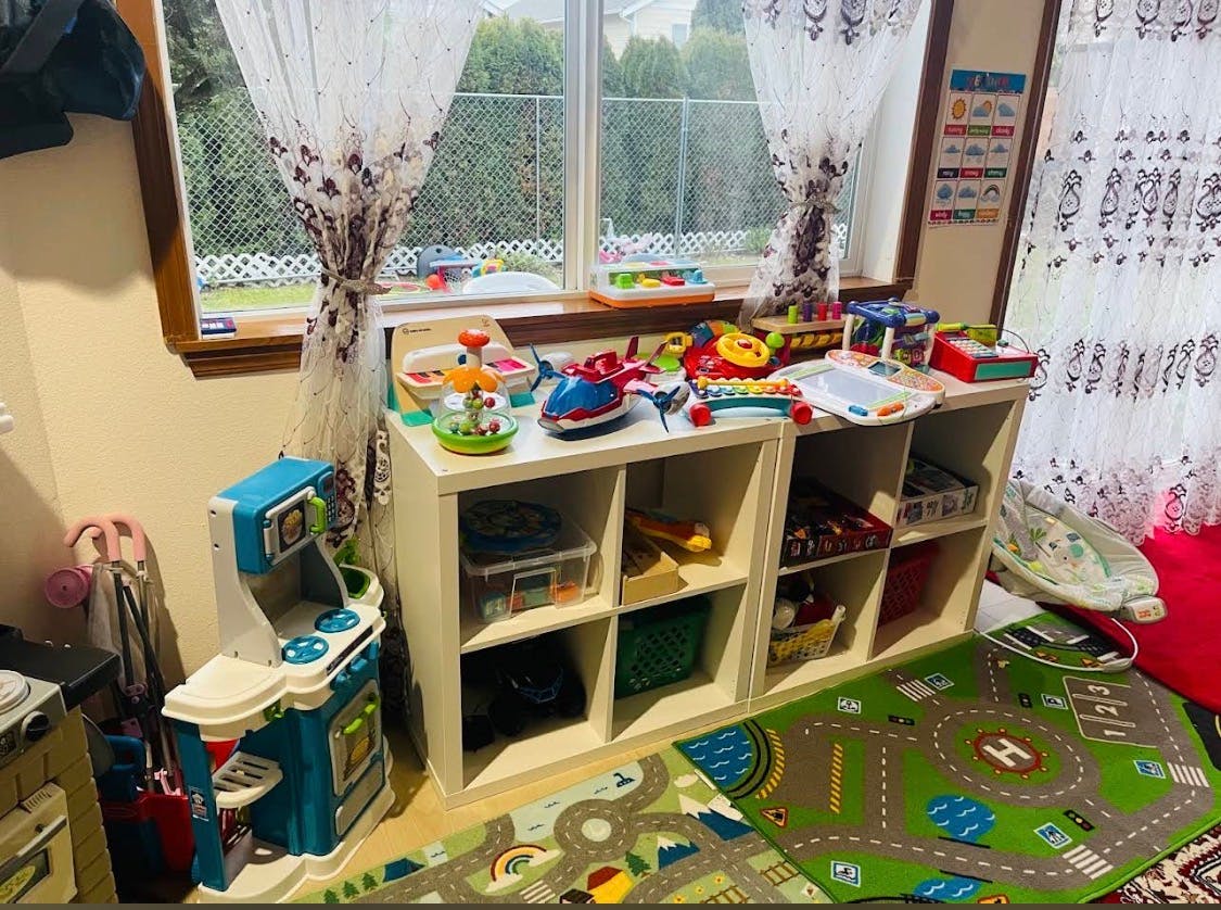 Playroom with toys on shelves, toy kitchen, and road map rugs