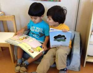 Two children sitting and reading books