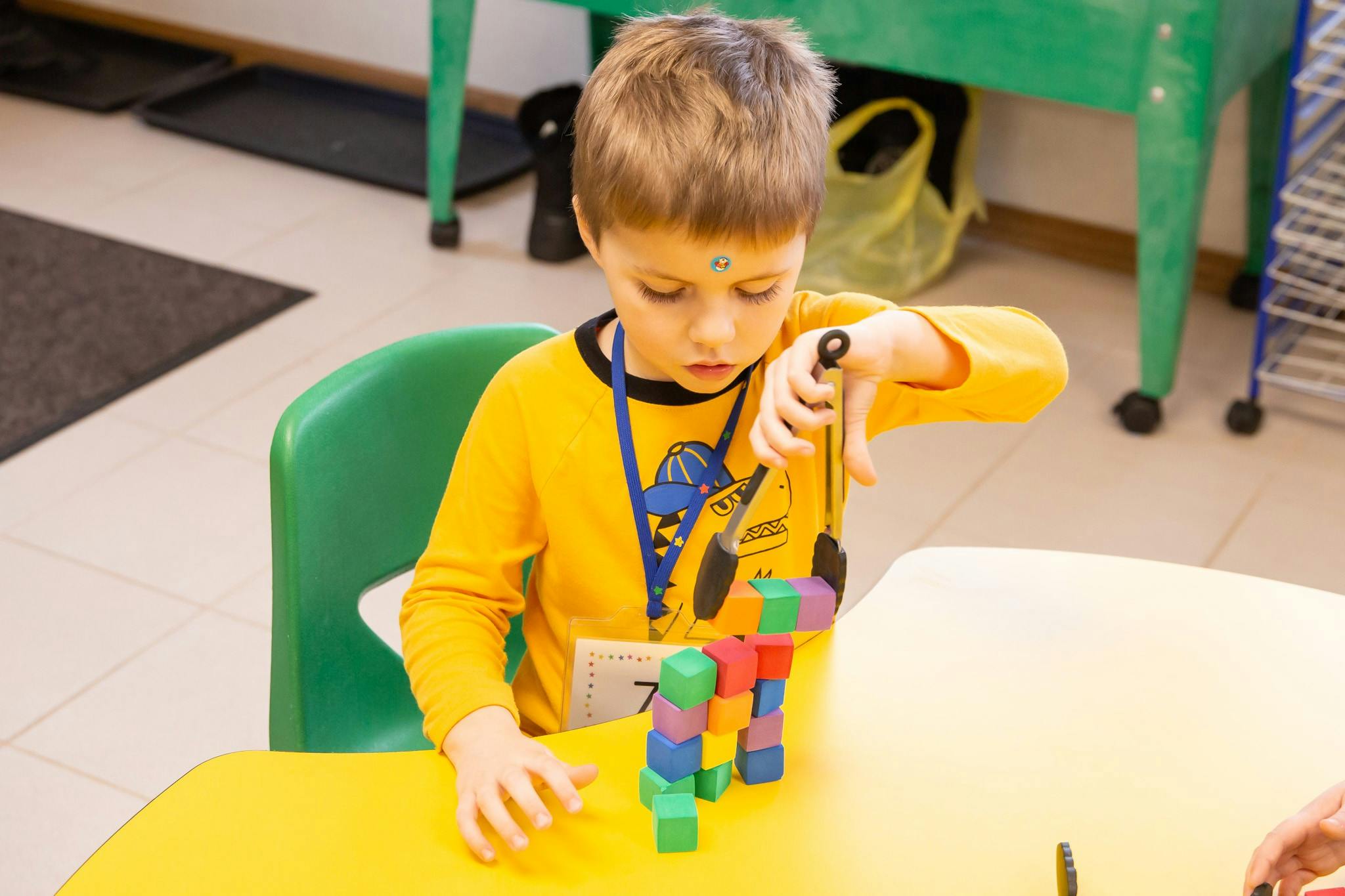 Child playing with colorful building blocks at a table