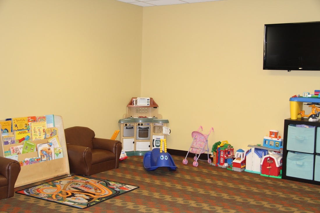 Children's play area with toys, small chairs, and a television