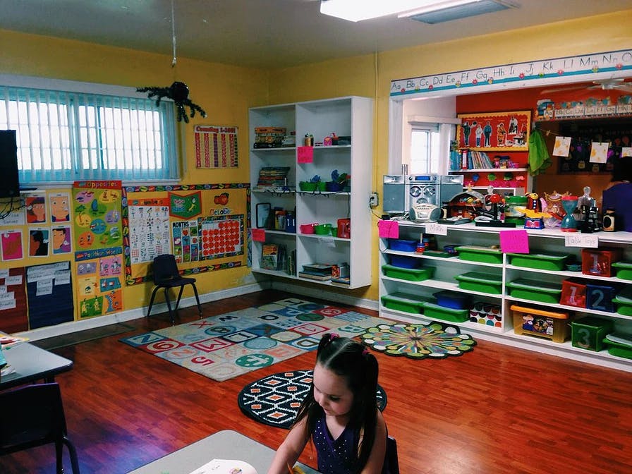 Child sitting at a table in a classroom