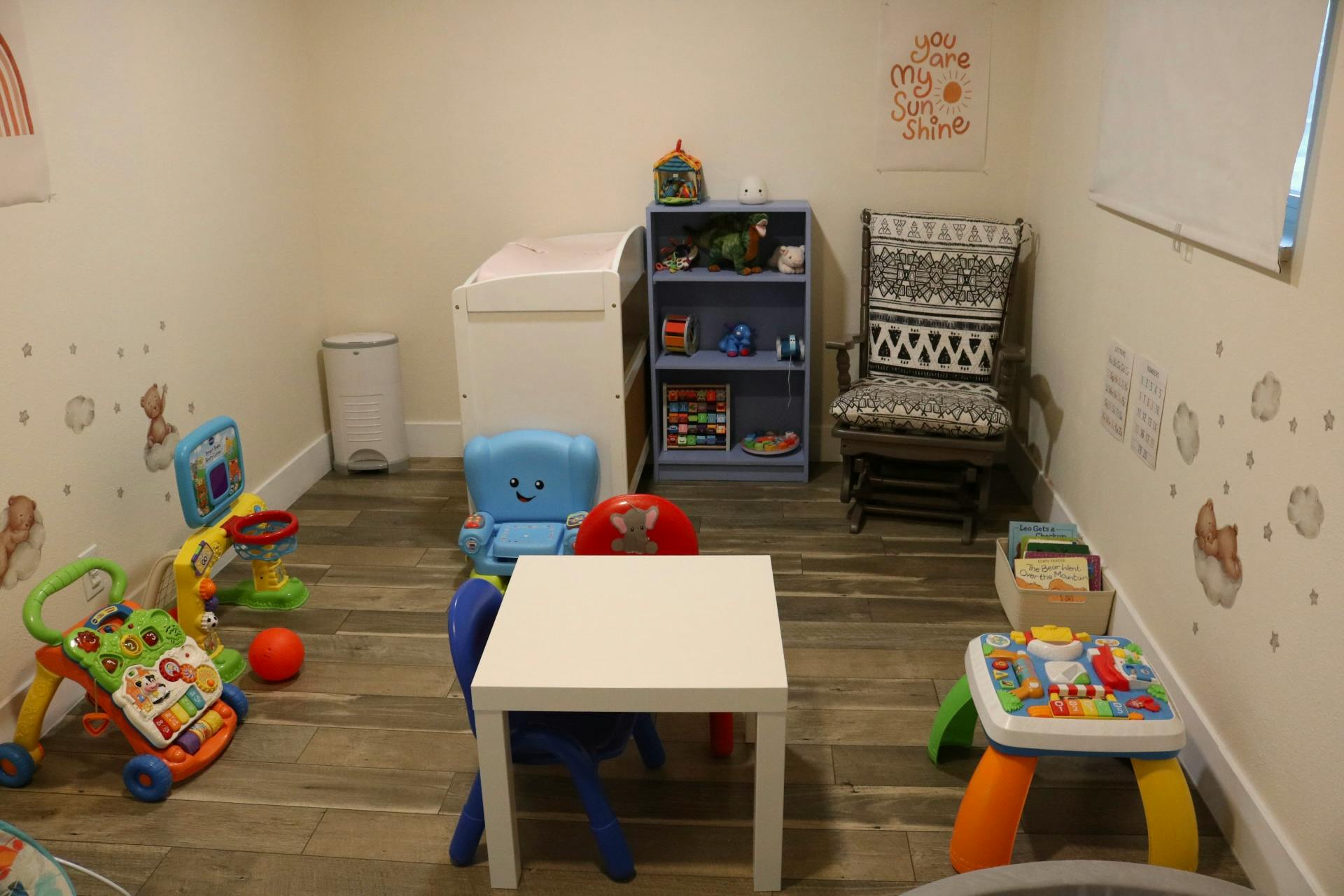 Playroom with small table and chairs, toys, and a bookshelf