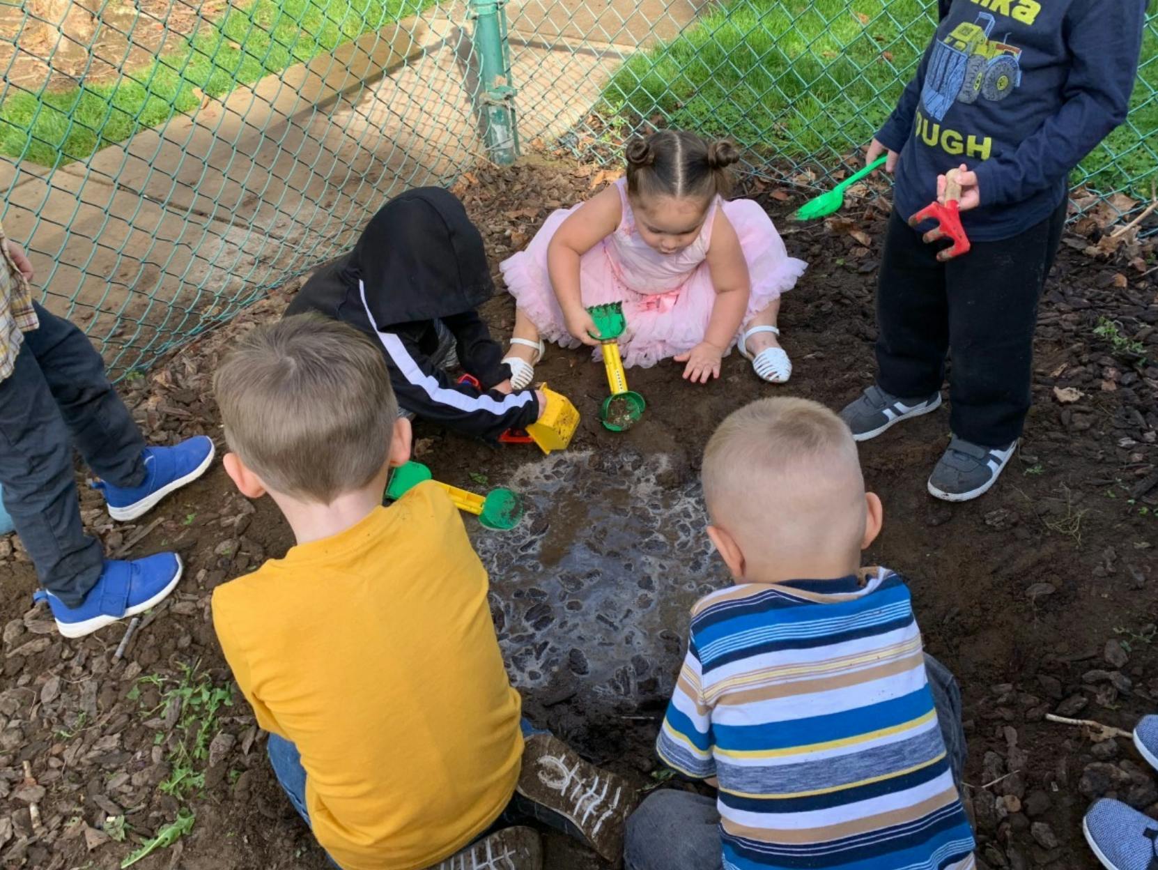 Children playing in dirt with toys
