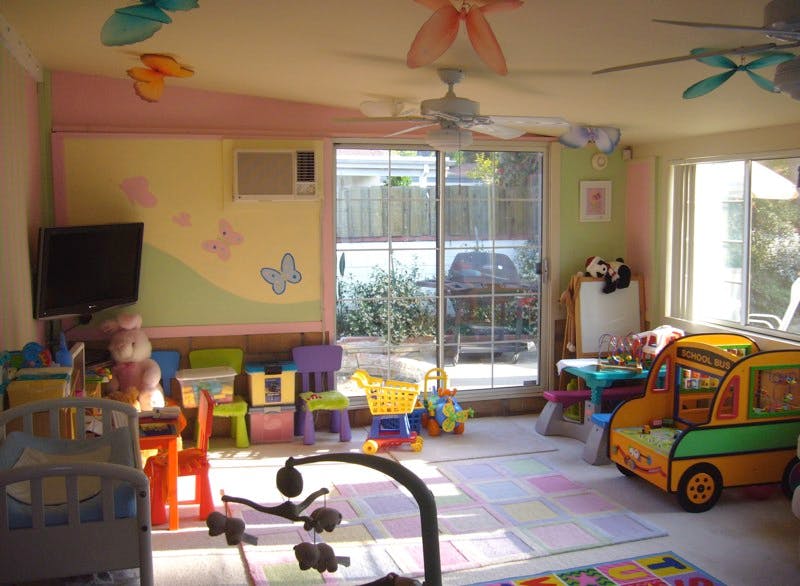 Playroom with toys, small chairs, and a toy bus