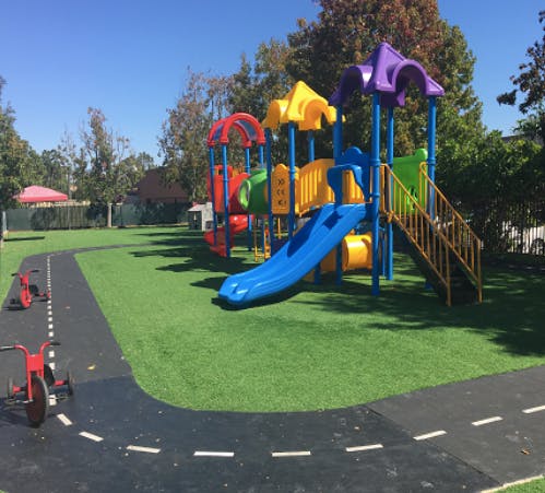 Colorful playground with slide and climbing structures on green turf