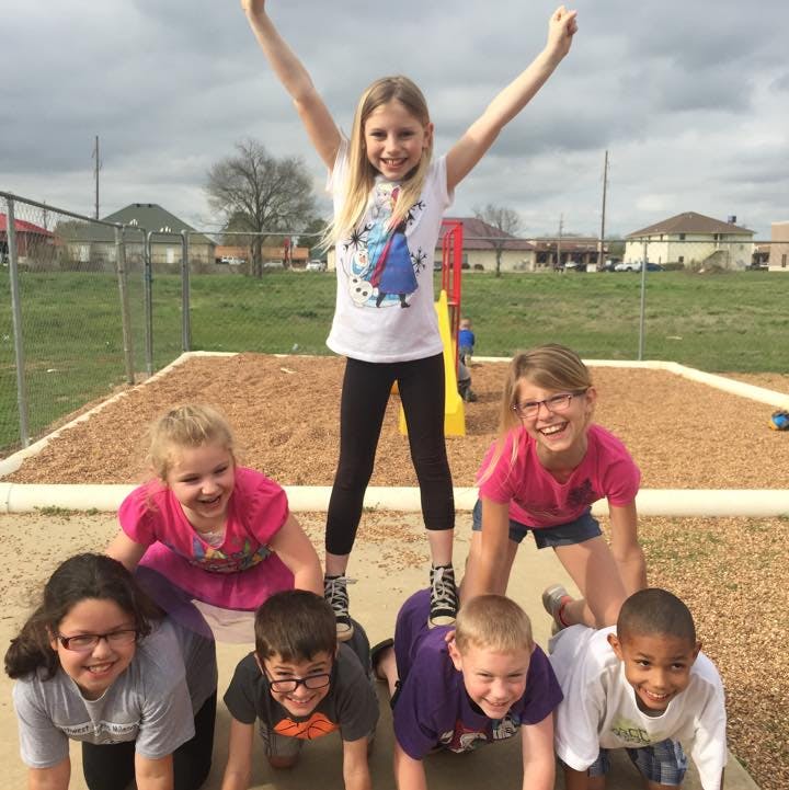 Children playing human pyramid on a playground