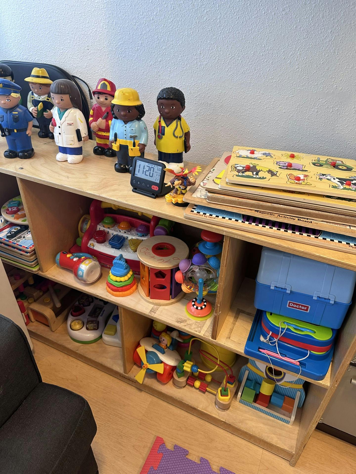 Shelf with various toys including figures, puzzles, and building blocks