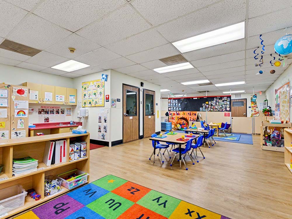 Colorful preschool classroom with small tables and chairs
