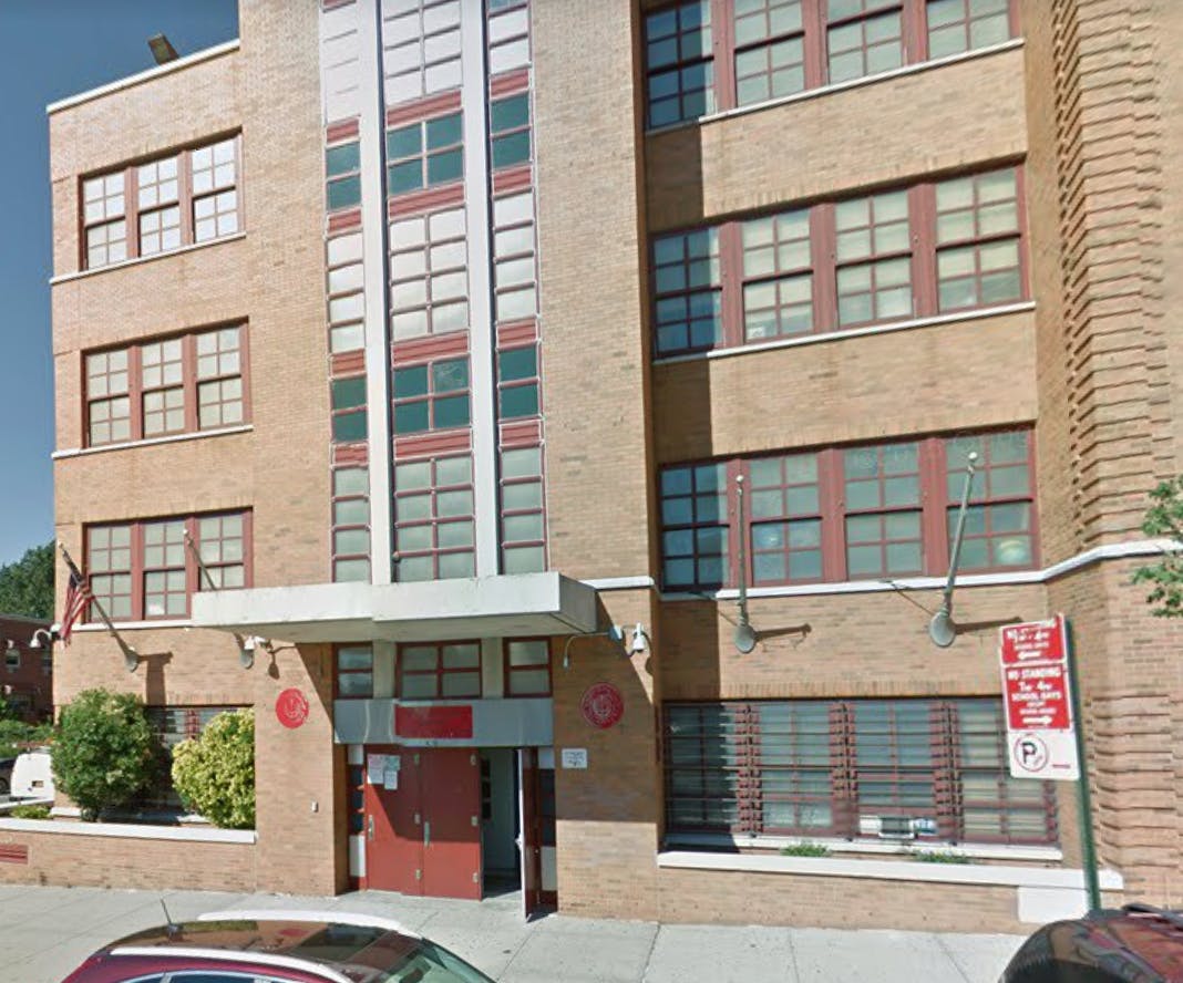 Exterior of a brick building with multiple windows and a red door