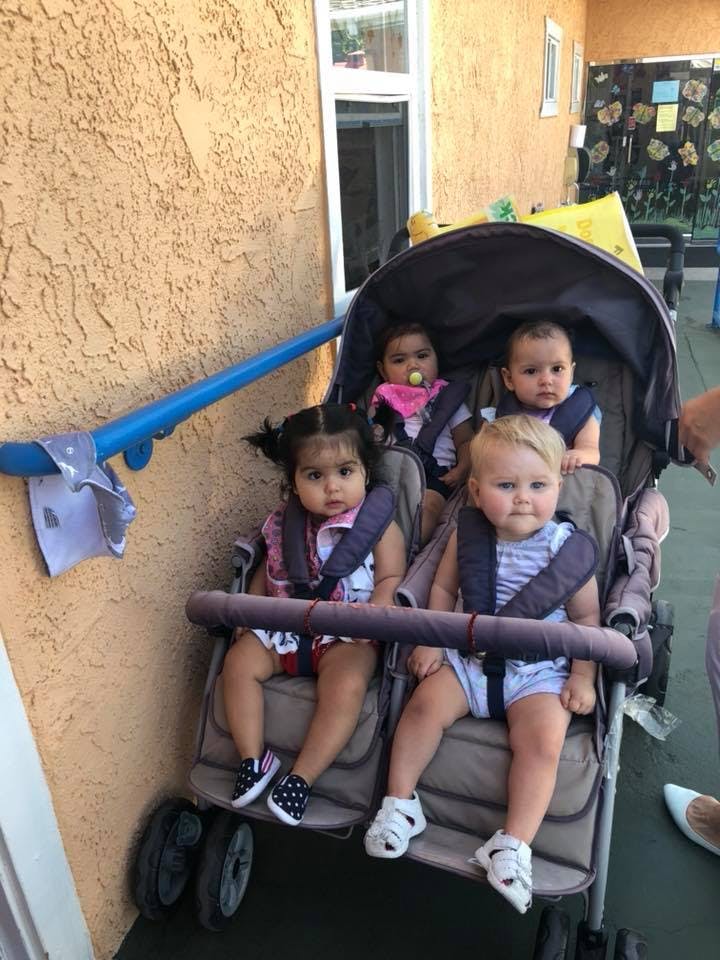 Four children in a multi-seat stroller