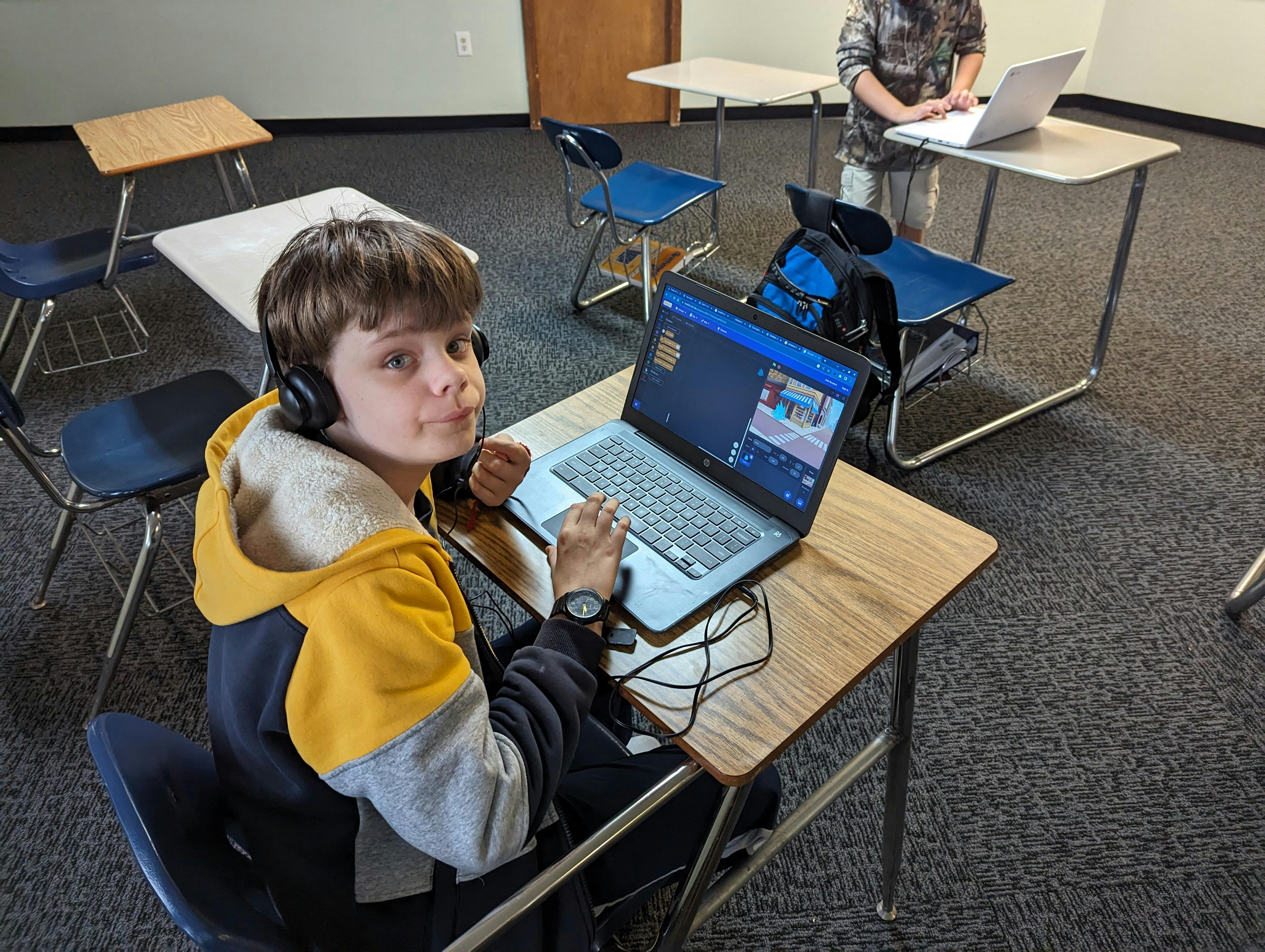 Child with headphones on using a laptop