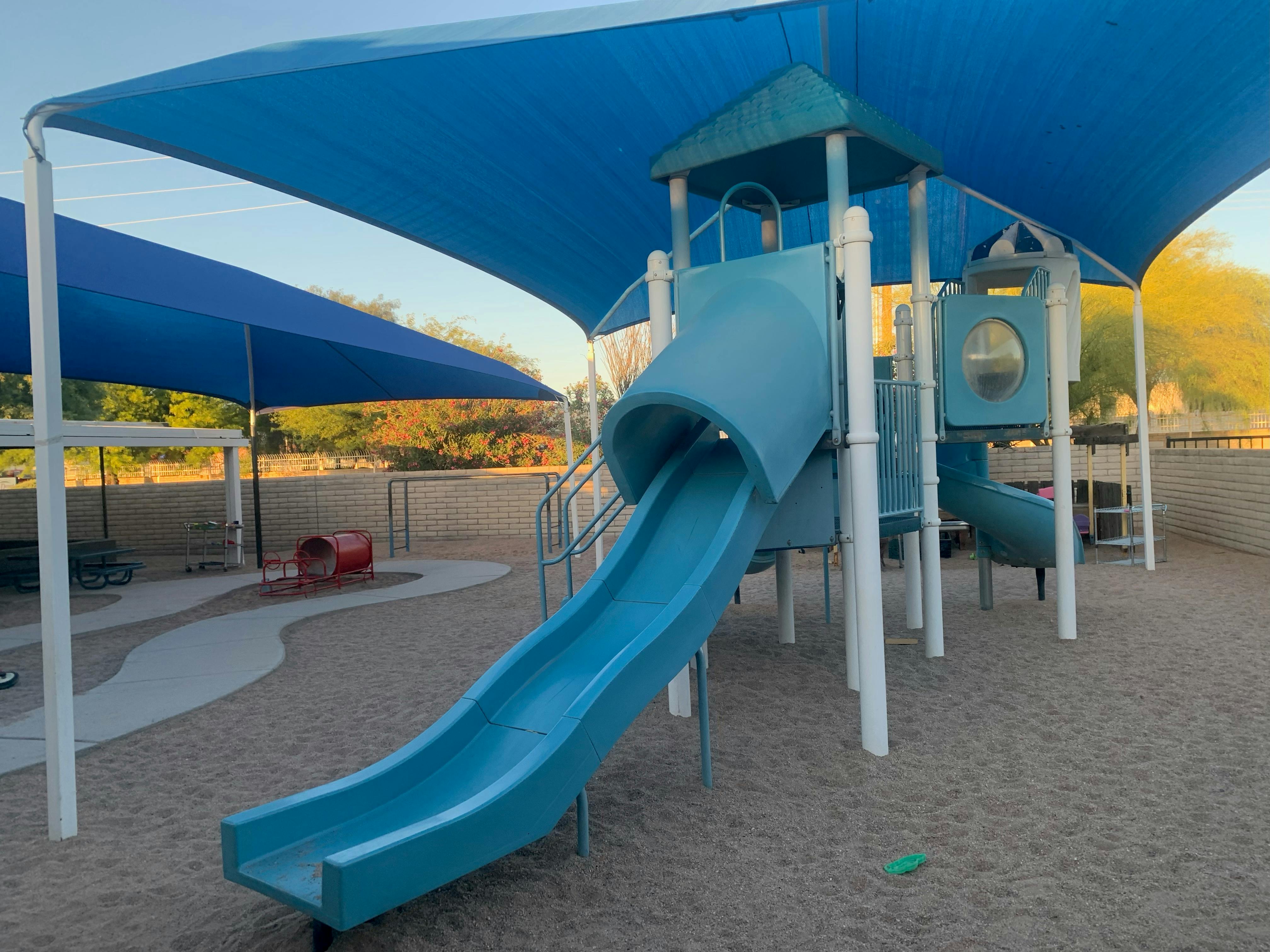 Playground with blue slides and shade structures