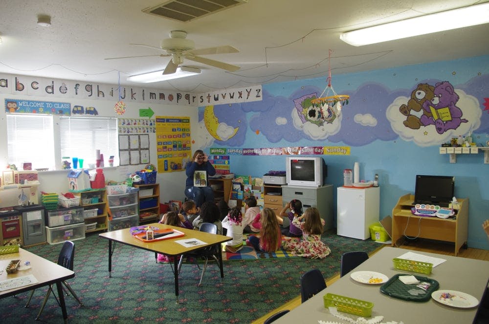 Adult reading to children in a classroom