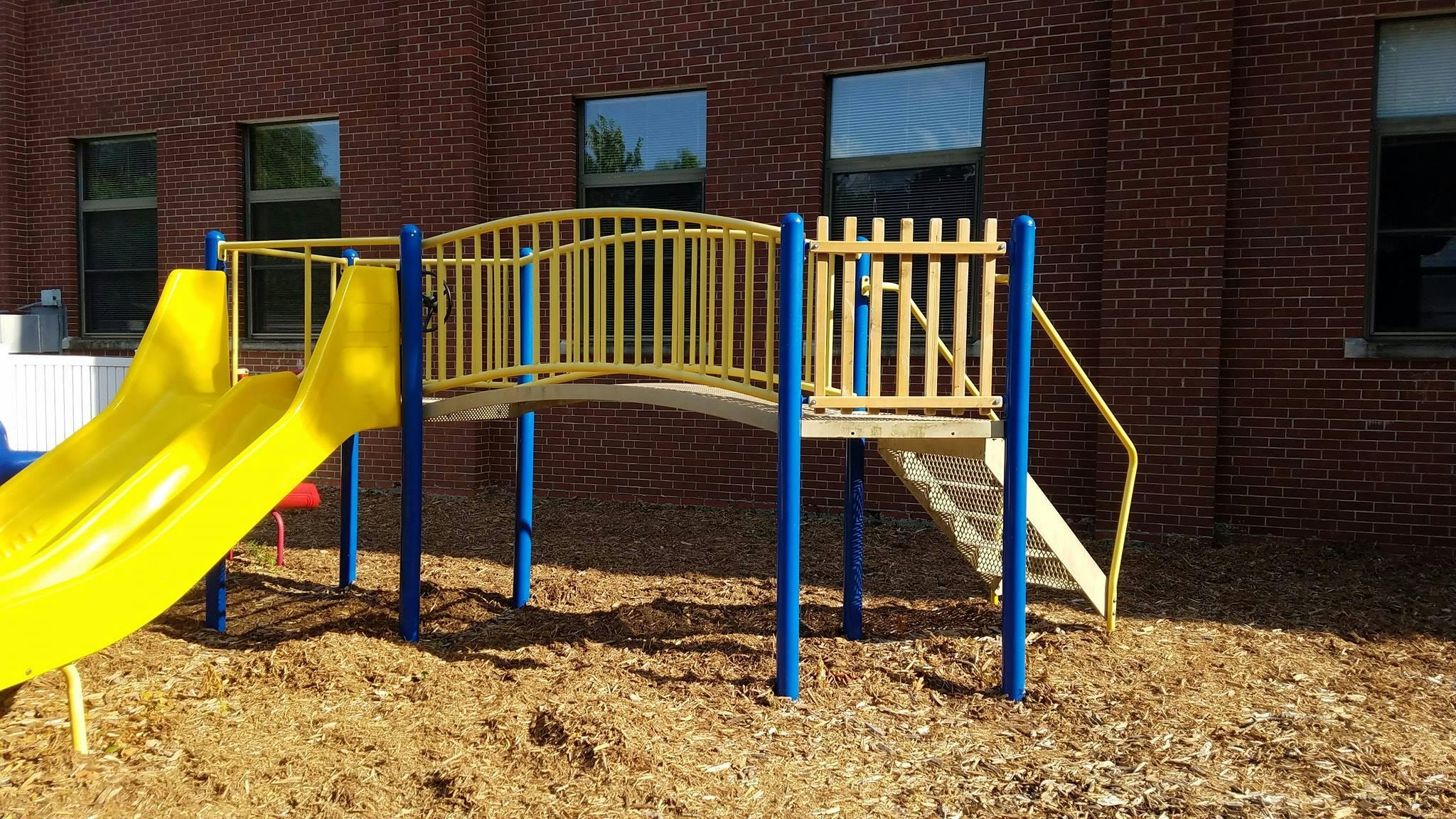 Yellow playground slide and bridge with blue supports