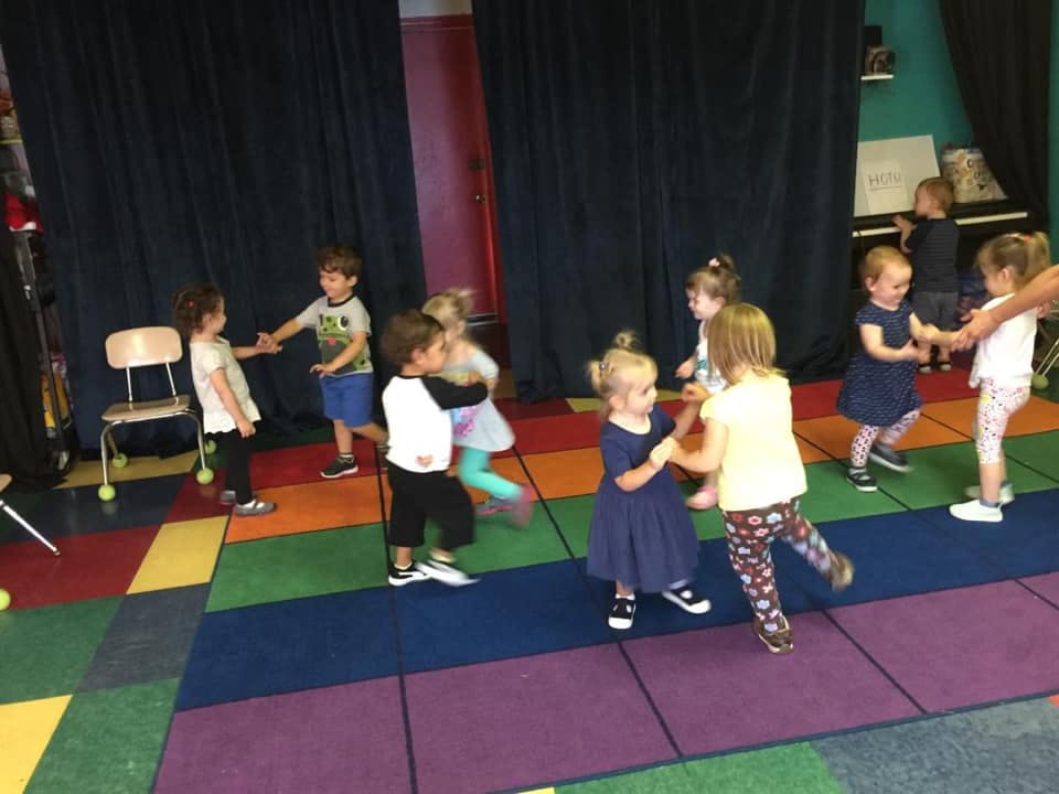 Group of children playing together on a colorful floor